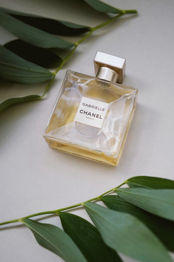 Bottle of perfume surrounded by leaves